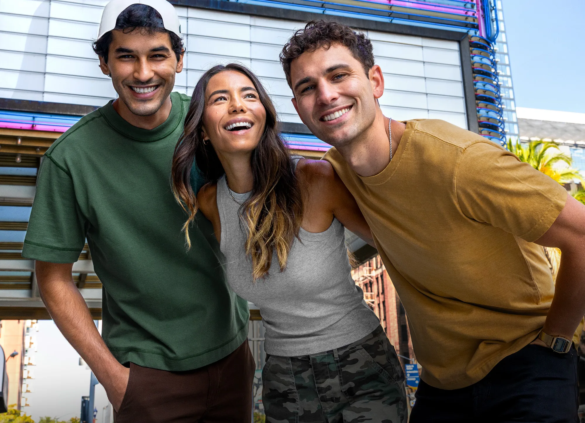 Three co-workers in branded tees and a cap